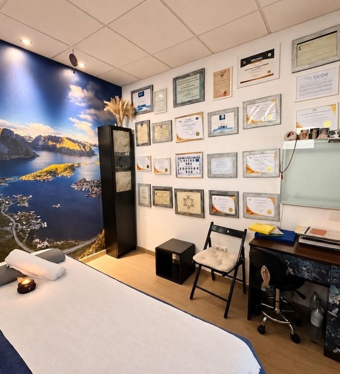 Sala de osteopatía de Luz Nature, con la camilla y la pared de titulaciones